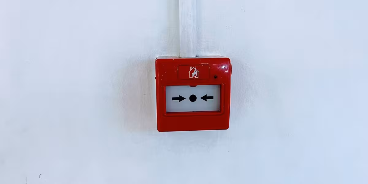 Botón manual de alarma contra incendio rojo en un muro blanco
