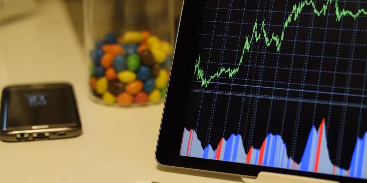 Tableta con gráfica de crecimiento junto a dulces de colores