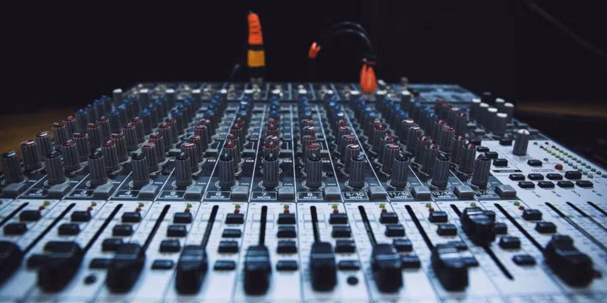 Consola de mezcla de audio con faders y perillas iluminadas
