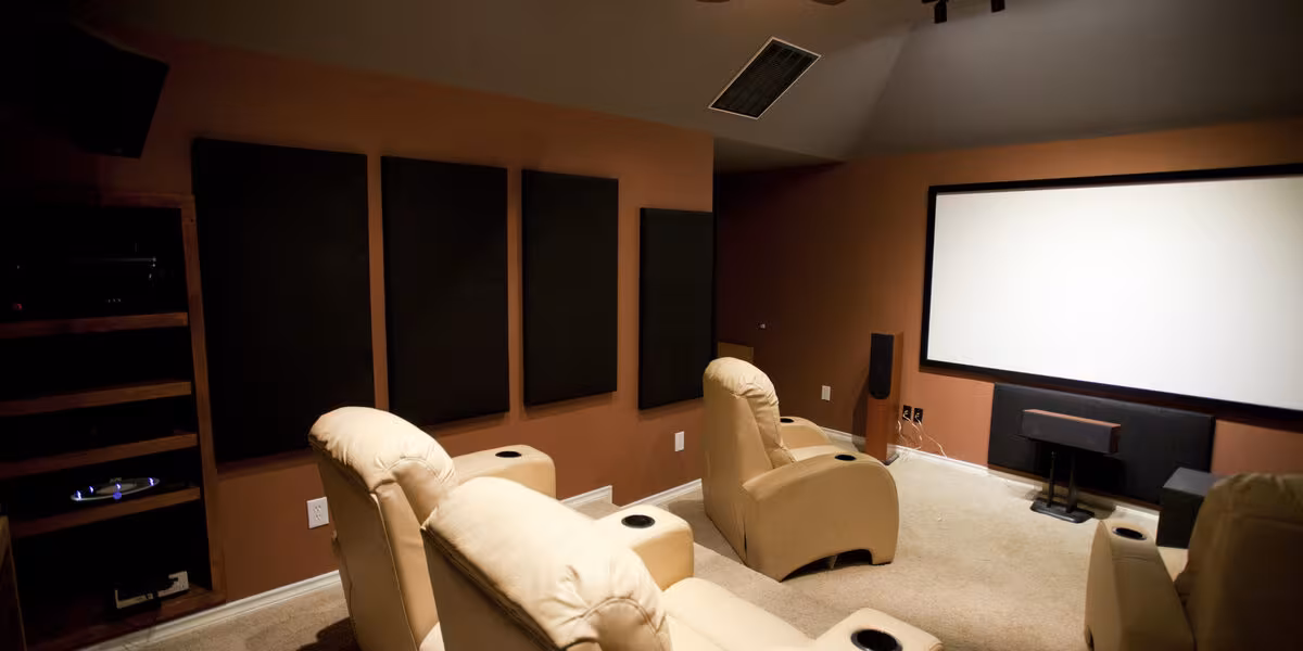 Sala de cine en casa con pantalla de proyección y sillones