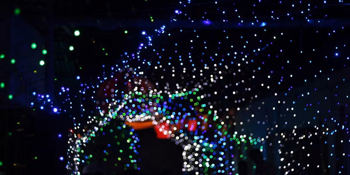 Luces de colores suspendidas sobre una celebración nocturna
