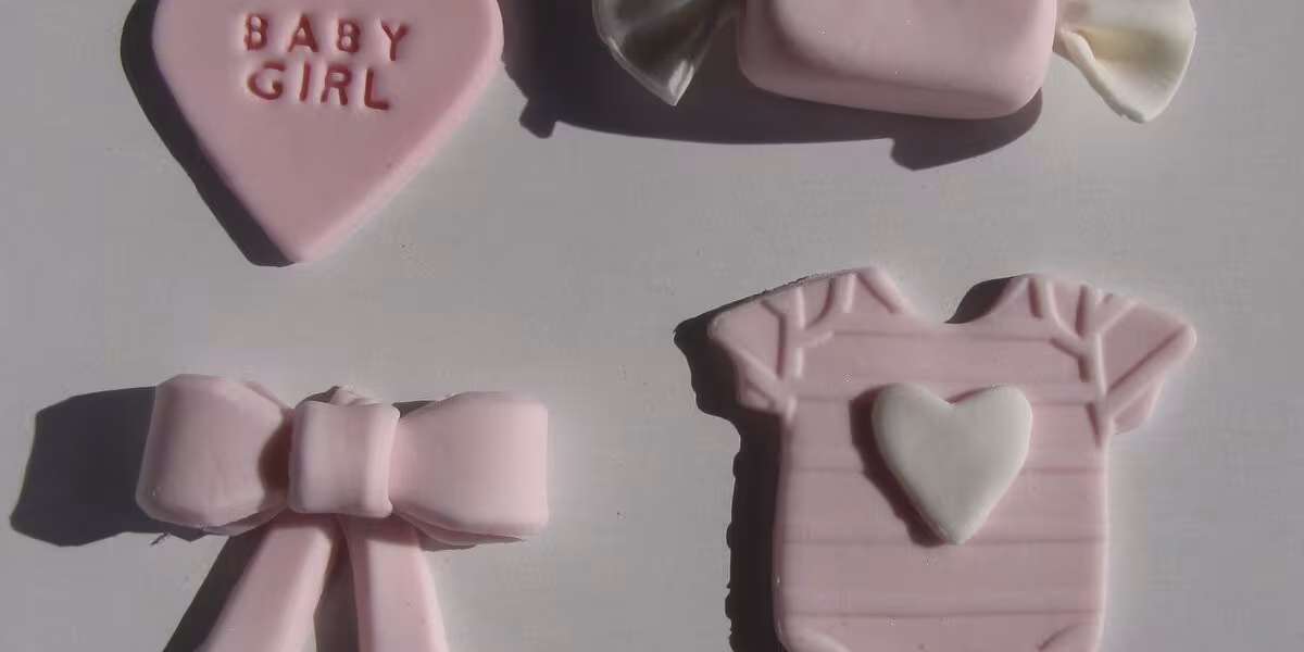 Decoraciones de fondant en tonos rosa para un baby shower