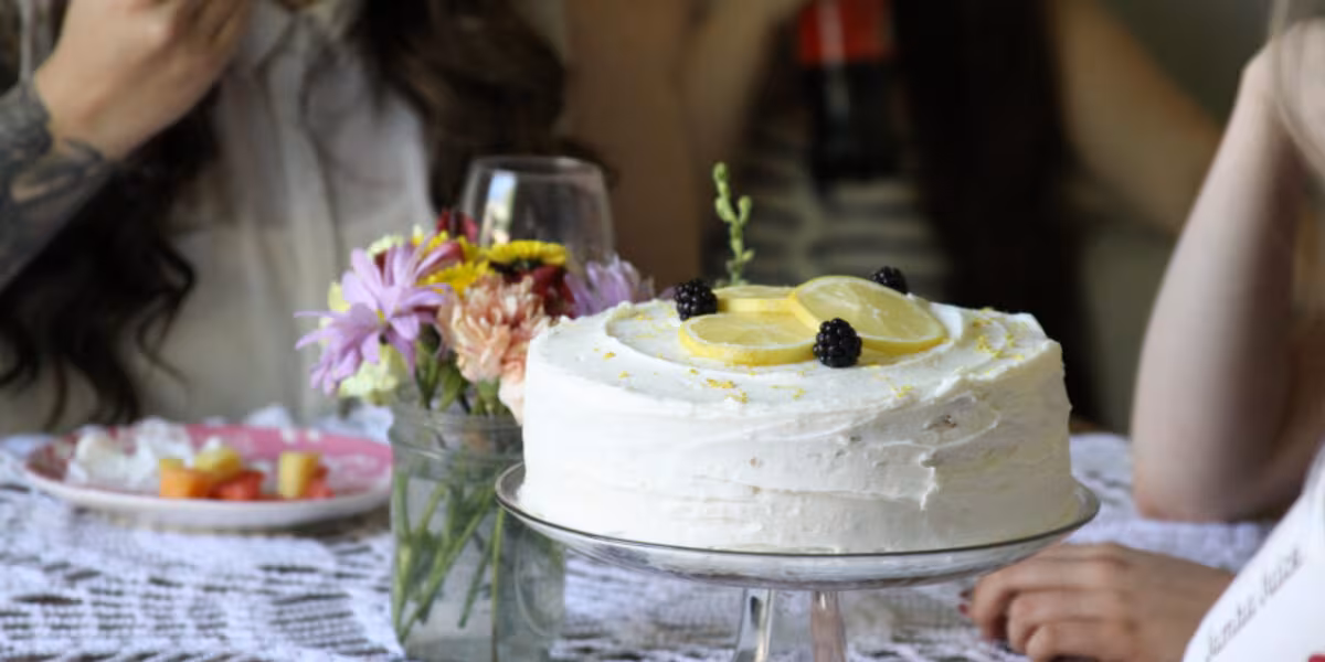 Pastel decorado con flores y copas en una celebración de adultos