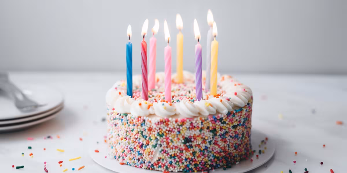 Pastel de cumpleaños con chispas de colores y velas encendidas
