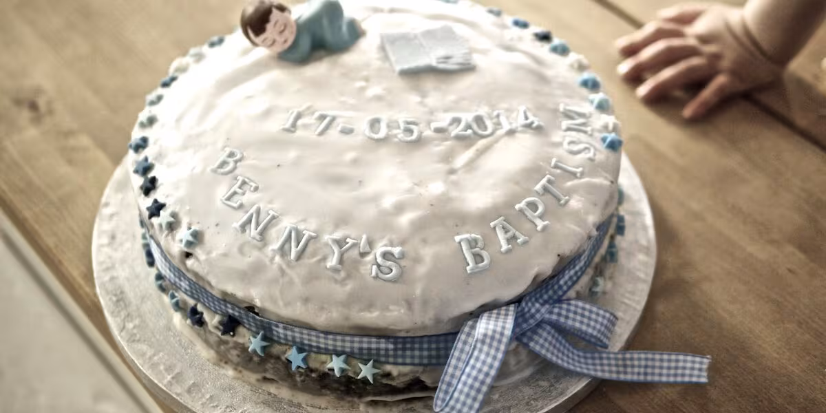 Pastel blanco decorado con listón para un bautizo