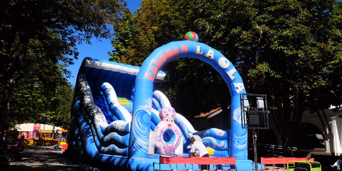 Brincolín inflable con arco de entrada instalado en un jardín