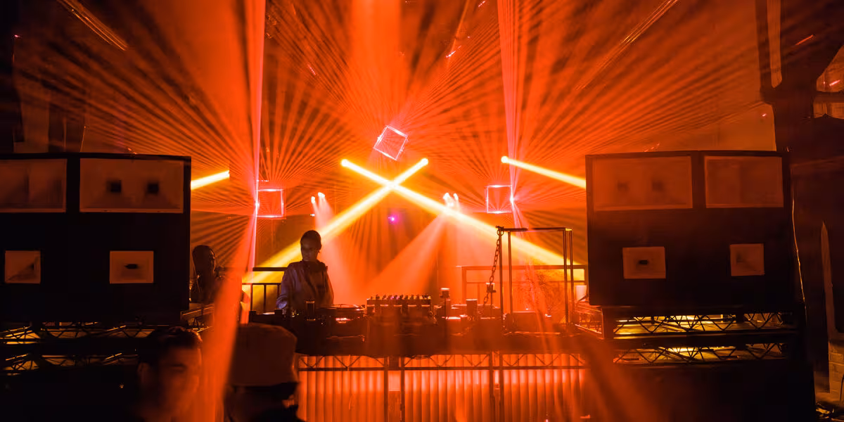 Montaje de iluminación con haces de luz naranja en un evento