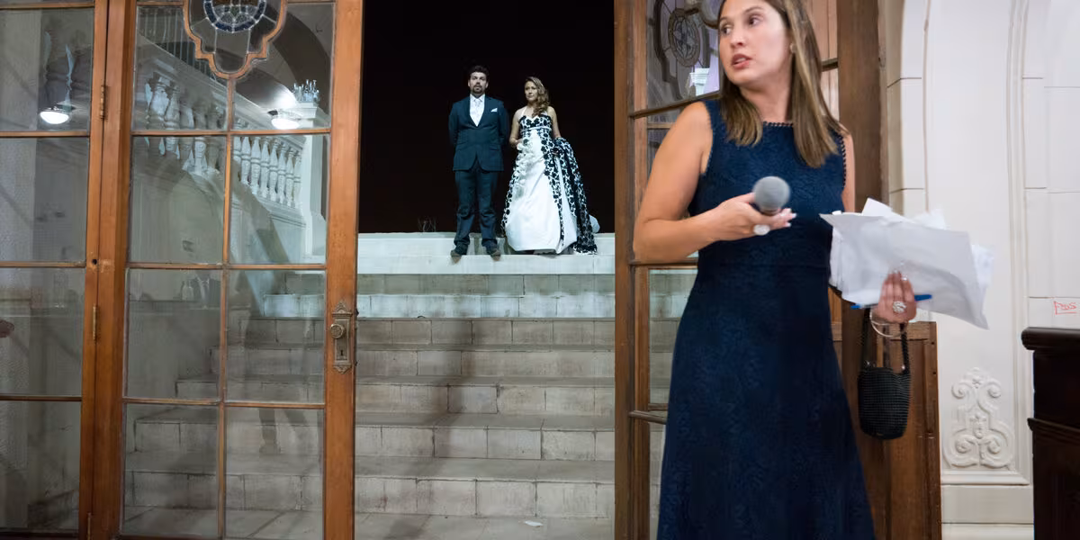 Organizadora de bodas con micrófono coordinando la entrada de los novios